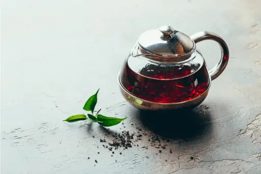 A kettle of black tea with leaves