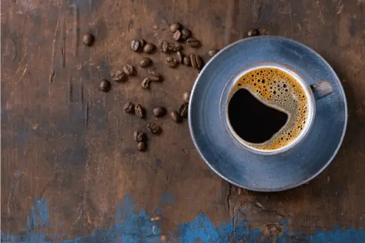 Black coffee in cup with coffee beans