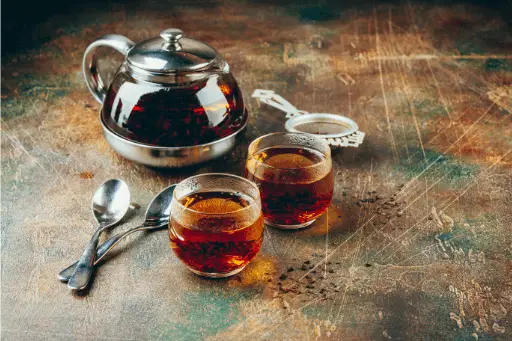 Black tea in two glass with kettle