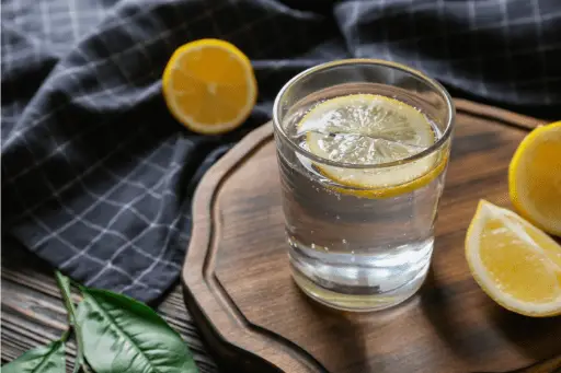 Lemon water in glass on wooden table