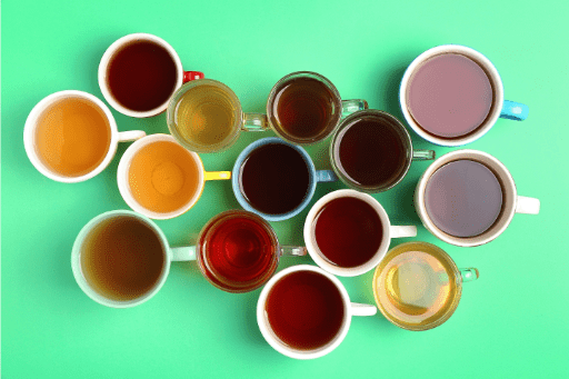 Cups of tea on green background