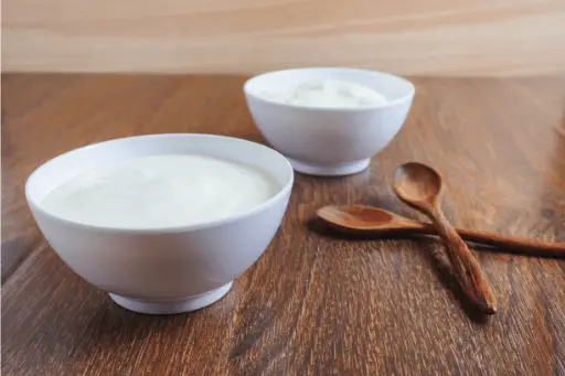 Curd in bowl on wooden table