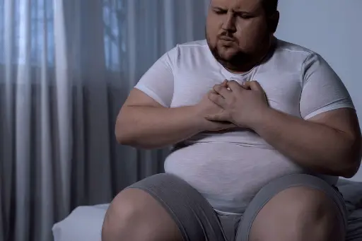 Fat man putting his hand on heart