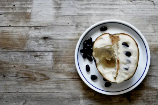 Custard apple with its seeds on plate