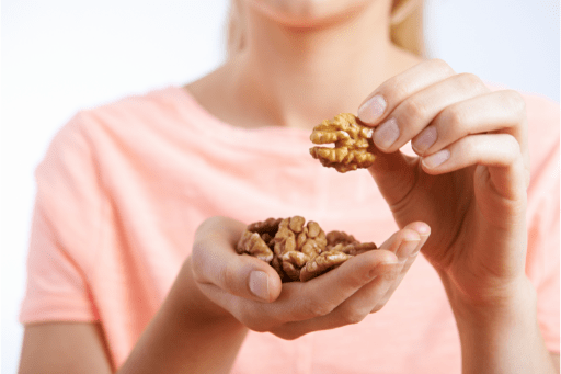 Closeup shot of woman eating walnuts