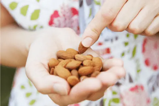 Women eating handful of almonds