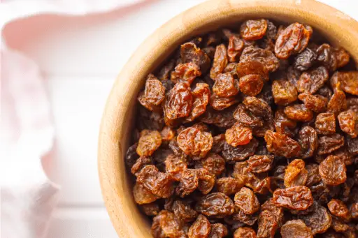 Red raisins in wooden bowl
