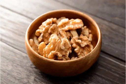 Walnuts without shell in a wooden bowl