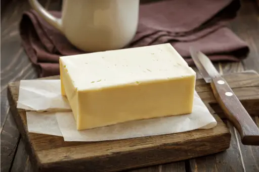 Butter with knife on wooden table