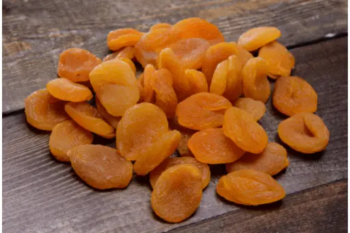 Dried apricots on wooden background