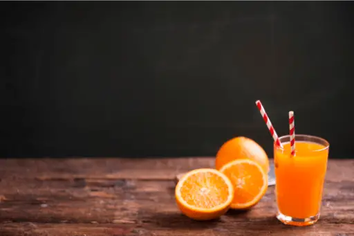 Orange juice in glass on wooden table