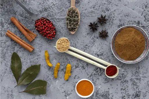 Various herbs and spices in bowl and spoons