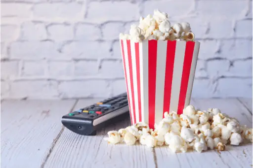 Popcorn in container and TV remote on table