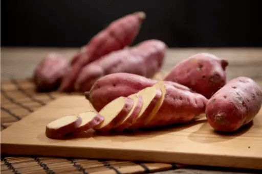 Raw sweet potato on wooden table