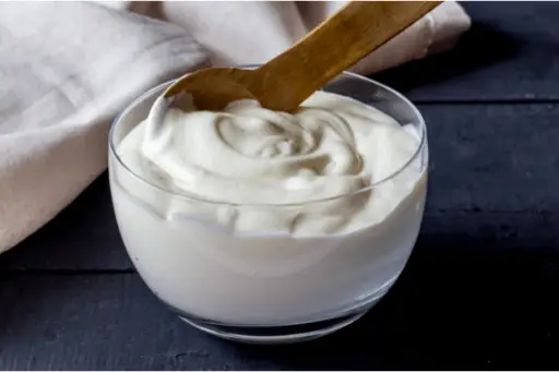 Curd with wood spoon in bowl